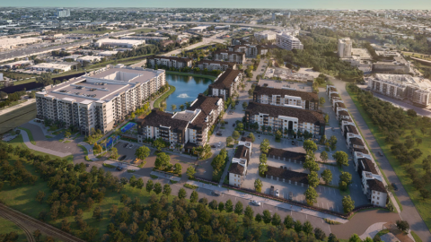 Aerial view of apartment buildings and housing with private streets, a lake, and greenery